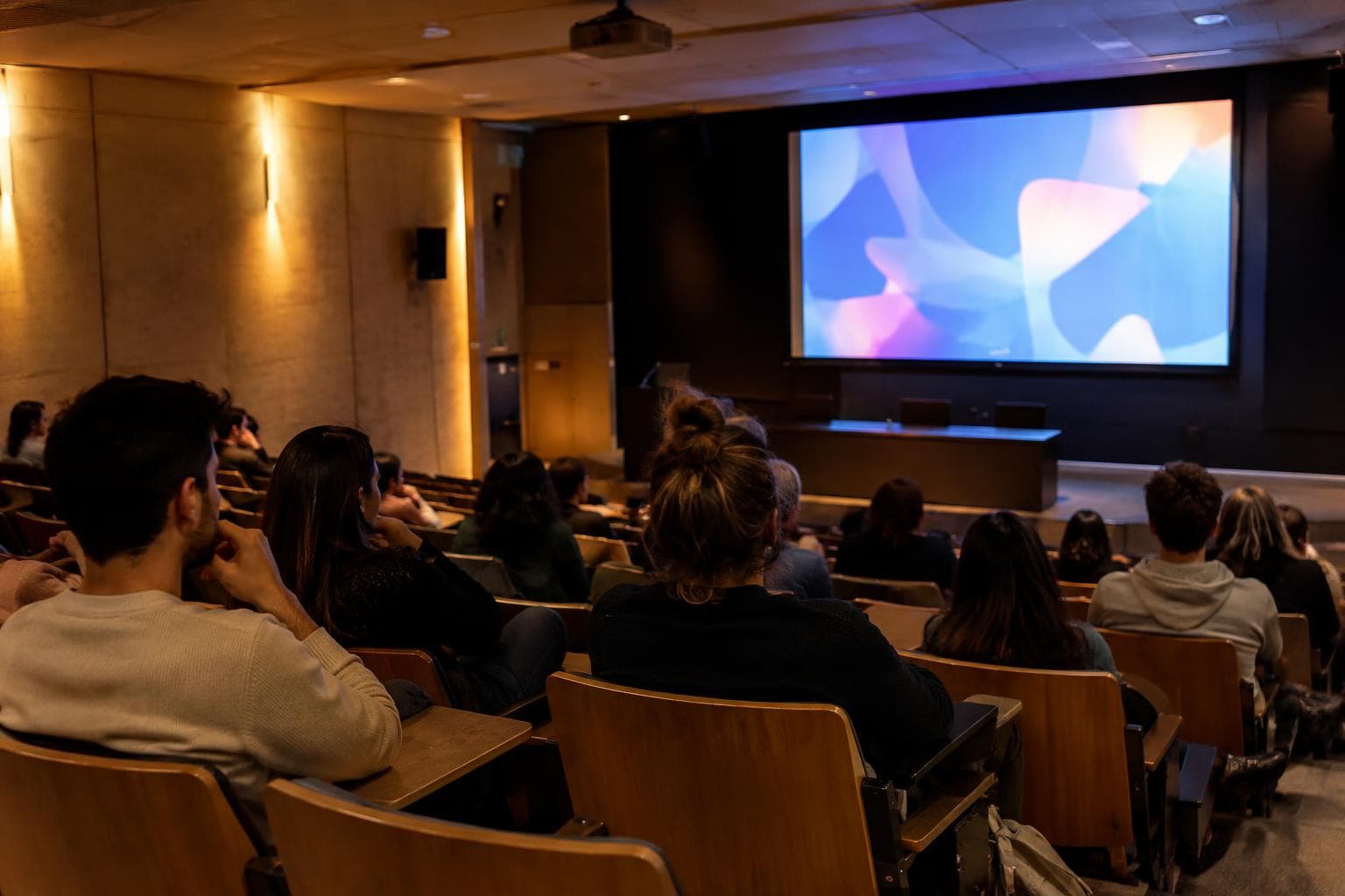 A university screening room with an audience watching an animation projection and no visible text.