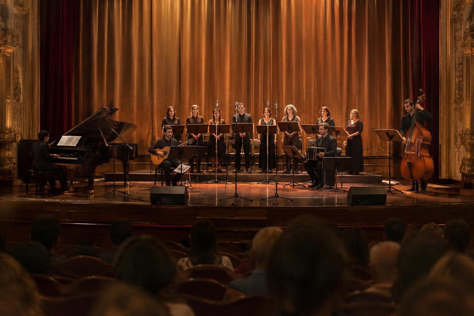 Un escenario teatral con coro y músicos antes de un concierto.