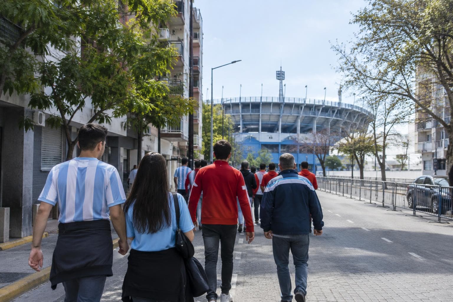 Hinchas caminando hacia un estadio urbano genérico en Avellaneda.
