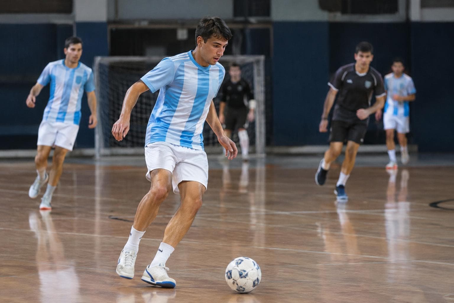 An indoor futsal court with generic players warming up.